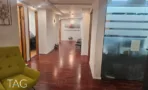 מסדרון פנימי עם רצפת פרקט, דלתות עץ לבנות ומחיצת זכוכית במשרד להשכרה של 267 מ