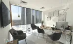 חדר עבודה עם כורסאות שחורות ותמונות ממוסגרות במשרד 148 מ״ר במגדל אקרו