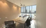 חדר ישיבות עם שולחן עץ ארוך ותאורת מסילה במשרד 148 מ״ר במגדל אקרו