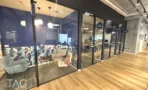 משרד להשכרה 650 מ״ר במגדלי הארבעה, פינת אירוח צבעונית מאחורי מחיצת זכוכית