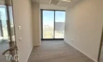 חדר עבודה במגדל אייקון עם חלון במסגרת שחורה ונוף אל האזור