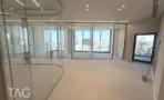 חלל פתוח עם מחיצות זכוכית מעוגלות וחלונות פנורמיים במגדל אייקון