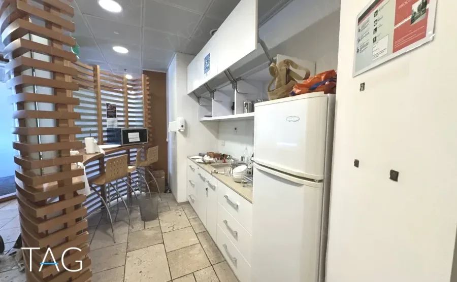 מטבחון עם מקרר, משטח עבודה ומחיצת עץ במשרד 374 מ