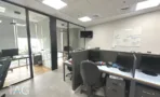 משרד להשכרה 92 מ״ר במגדל WE, אופן ספייס עם עמדות עבודה ולוח מחיק לצד חדרים מזוגגים