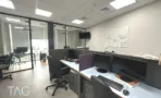 משרד להשכרה 92 מ״ר במגדל WE, עמדות עבודה עם מסכים באופן ספייס מול חדרי זכוכית