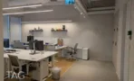 משרד להשכרה 450 מ״ר במגדל WE, אזור עבודה פתוח עם עמדות מחשב ומדפי תצוגה