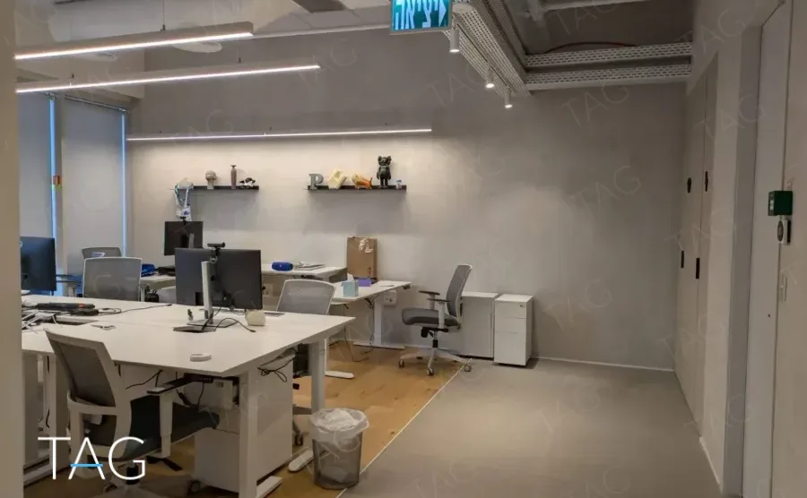 משרד להשכרה 450 מ״ר במגדל WE, אזור עבודה פתוח עם עמדות מחשב ומדפי תצוגה