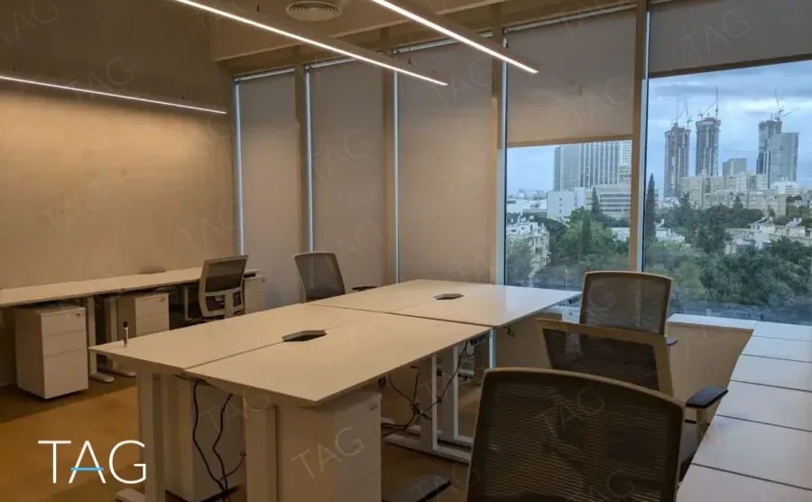 משרד להשכרה 450 מ״ר במגדל WE, שולחנות עבודה מול חלונות עם נוף לעיר