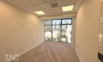 משרד להשכרה בבית יעקב - חדר עם רצפת פרקט וחלון פינתי הנשקף אל קו הרקיע של העיר - תג נכסים