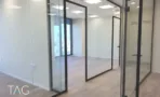 חדרים מופרדים במחיצות זכוכית על רצפת פרקט בהיר במגדל אייקון