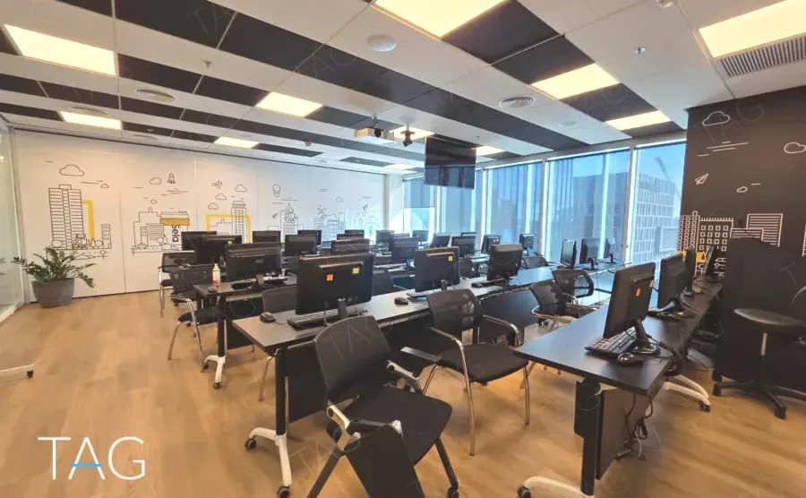 אזור אופן ספייס במשרד להשכרה במגדל אלייד בבני ברק עם שורות עמדות עבודה וקיר איורים - תג נכסים