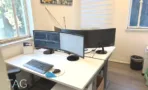 שולחן עבודה לבן עם מסכים מול חלון במשרד להשכרה בתל אביב - תג נכסים