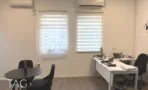 חדר עבודה עם שולחן עגול ווילונות זברה במשרד להשכרה בתל אביב - תג נכסים