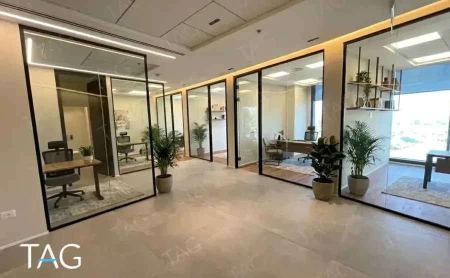 משרד מאויש במגדל אייקון עם עמדות עבודה, צמחייה וחדרי זכוכית