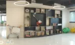 קיר יחידות כהה עם תאים פתוחים ותאורת טבעת במשרד להשכרה באזור רוטשילד - תג נכסים