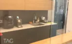 מטבחון עם משטח כהה, ארונות עץ עליונים ומכונת קפה