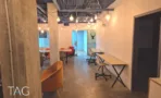 אזור העבודה המשותף במשרד להשכרה ברחוב אחד העם תל אביב, תקרה חשופה, עמוד בטון ושולחנות עבודה - תג נכסים