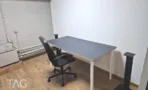 חדר עבודה במשרד להשכרה ברחוב אחד העם תל אביב, שולחן יחיד לצד קיר לבן וצנרת גלויה - תג נכסים