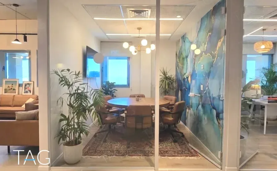 משרד להשכרה 398 מ״ר במגדלי אלון הייטק, חדר ישיבות עם שולחן עגול וקיר אמנותי בגווני כחול