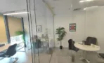 חדר עבודה מזוגג עם שולחן עגול וצמח