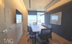 חדר ישיבות עם שולחן ארוך, קיר כהה ונוף העיר