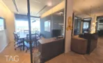 חדר ישיבות מזוגג לצד דלפק קבלה מעץ, עם נוף העיר