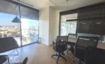 חדר עבודה עם עמדות, תאורה תלויה ונוף העיר