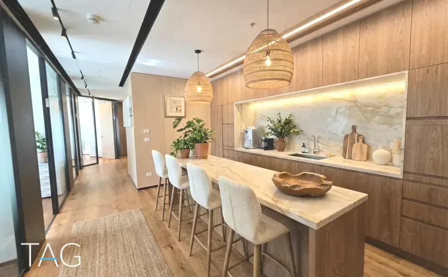 מטבח אירוח במשרד במגדל ספיר עם אי שיש וגופי תאורה קלועים