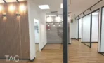 קיר רפפות עץ מול מחיצות זכוכית ורצפת עץ במשרד 134 מ״ר במגדל אקרו