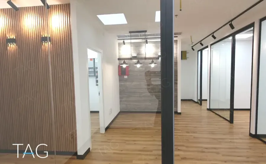 קיר רפפות עץ מול מחיצות זכוכית ורצפת עץ במשרד 134 מ״ר במגדל אקרו