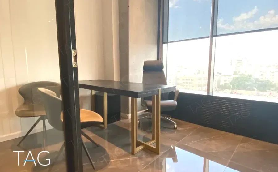 משרד למכירה 75 מ״ר במגדל WE, חדר מנהלים עם שולחן שחור וכיסא מנהלים מול החלון
