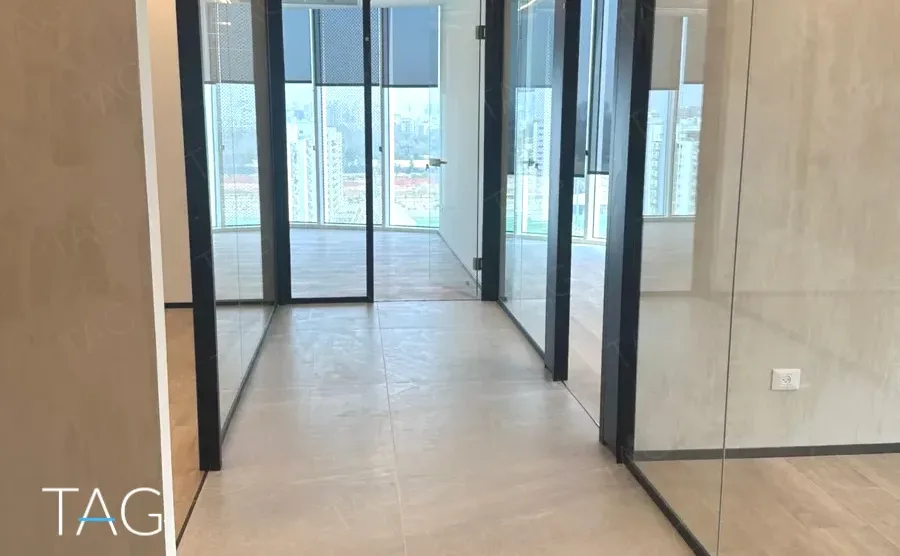 חלל משרדי בACRO BUSINESS CAMPUS עם מחיצות זכוכית, קיר טיח וחלונות רחבים - תג נכסים