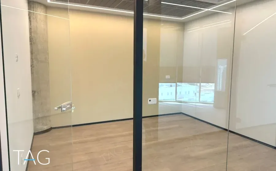 חדר מזוגג בACRO BUSINESS CAMPUS עם עמוד בטון, פרקט עץ ותאורה ליניארית - תג נכסים