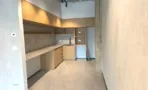 מטבח משרדי בACRO BUSINESS CAMPUS עם חיפוי עץ, מדפים פתוחים ומשטח ארוך - תג נכסים