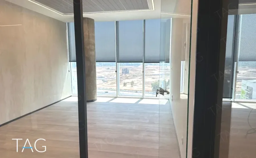 משרד בACRO BUSINESS CAMPUS עם קיר טיח מרוח, וילונות גלילה ופרקט עץ - תג נכסים