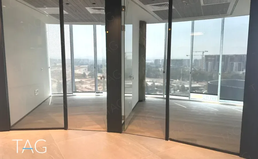 אזור משרדי בACRO BUSINESS CAMPUS עם מחיצות זכוכית שחורות ורצפת אריחים - תג נכסים