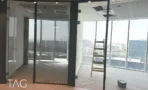 חלל משרדי בACRO BUSINESS CAMPUS עם חדרי זכוכית, תקרה מחורצת ונוף עירוני - תג נכסים