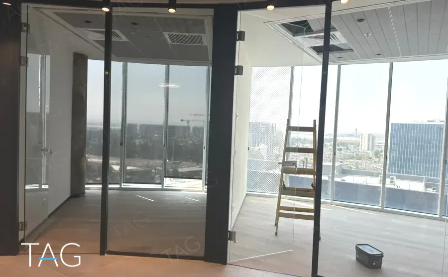 חלל משרדי בACRO BUSINESS CAMPUS עם חדרי זכוכית, תקרה מחורצת ונוף עירוני - תג נכסים