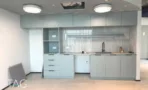 מטבח משרדי בACRO BUSINESS CAMPUS עם ארונות אפורים בהירים וחיפוי מחורץ - תג נכסים