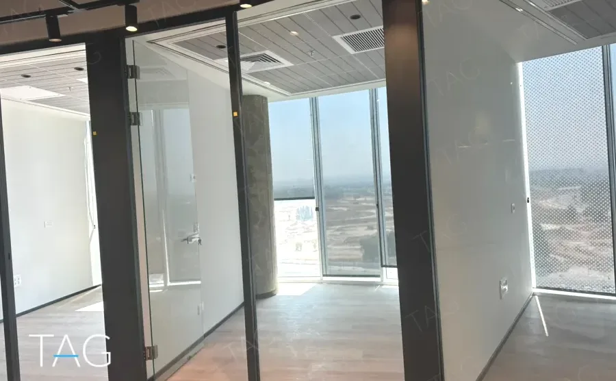 חלל משרדי בACRO BUSINESS CAMPUS עם מחיצות זכוכית, עמוד בטון וחלונות היקפיים - תג נכסים