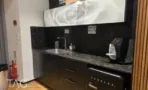 מטבחון המשרד במגדל ספיר עם משטח שיש כהה ומקרר עיצובי