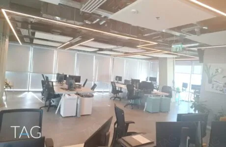 חלל עבודה פתוח עם עמדות מחשב ותאורת פס במגדל רוטשילד 22