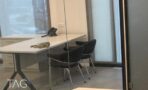 פינת הקבלה עם דלפק מזוותת, ומאחוריה חדר זכוכית עם שולחן וכיסאות