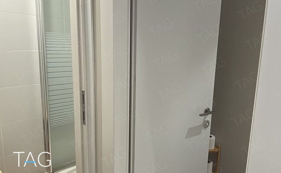 חדרי שירותים עם דלתות לבנות וריצוף אפור במשרד במגדל פלטינום