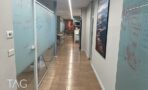 מסדרון עם קירות זכוכית חלבית ופרקט עץ בין חדרי העבודה במשרד בתל אביב
