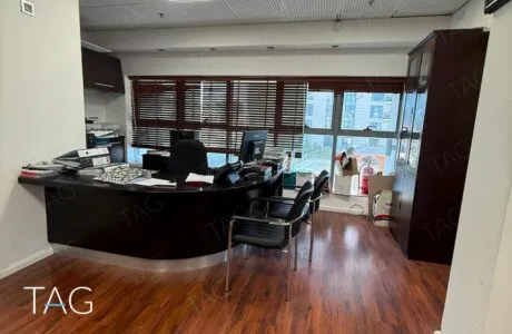 אזור הכניסה במשרד להשכרה בבית שחף תל אביב, עמדת קבלה מעוגלת, ריצוף בגוון עץ ותקרה אקוסטית