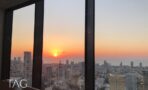 שקיעה מעל קו החוף ומגדלי תל אביב כפי שנראה דרך חלונות משרד במגדל מידטאון