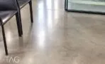 רצפת בטון מוחלקת וכיסאות שחורים ליד מחיצת זכוכית באזור המשרד בתל אביב