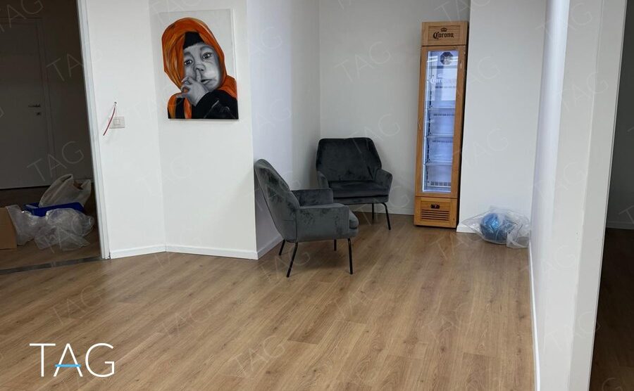פינת המתנה עם כורסאות קטיפה אפורות ותמונה על הקיר במשרד בשכונת מונטיפיורי