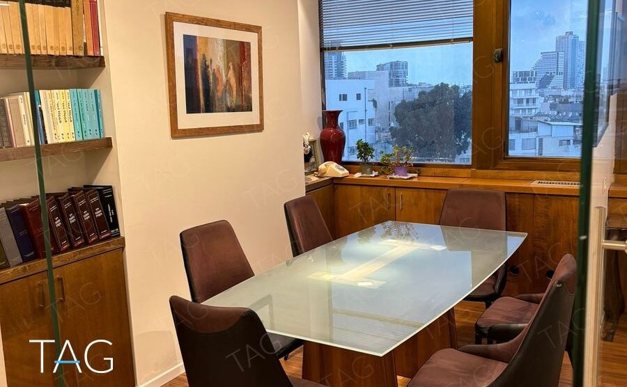 חדר ישיבות עם שולחן זכוכית ומנורות כרום תלויות במשרד להשכרה במגדל שלום מאיר תל אביב